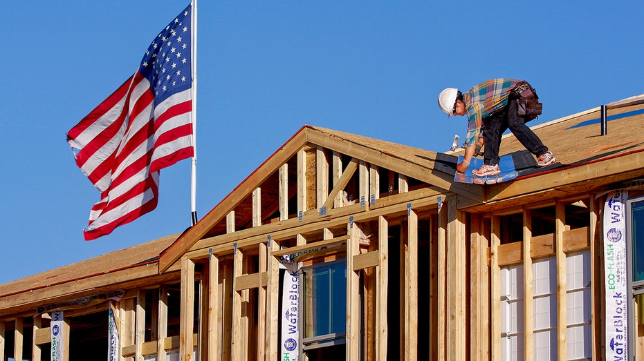 Construction workers builds home with US flag in background